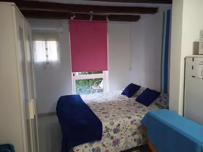 a bedroom with a bed with blue pillows and a window at Estudio con balcon Plaza España in Barcelona