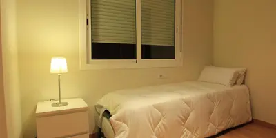 a small bedroom with a bed and a window at Alguera Apartments Industria in Barcelona