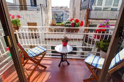 a balcony with a table and chairs and flowers at Aquarium Apartment by Hello Homes Sitges in Sitges