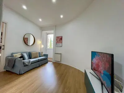 a living room with a couch and a tv at The Gaudi Suites in Barcelona
