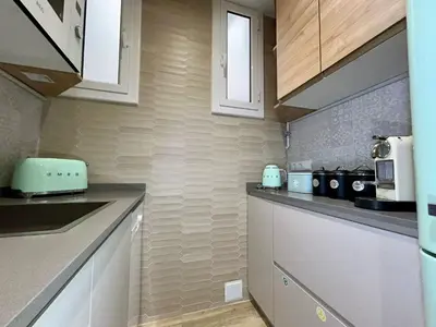 a kitchen with white counters and white cabinets at The Gaudi Suites in Barcelona