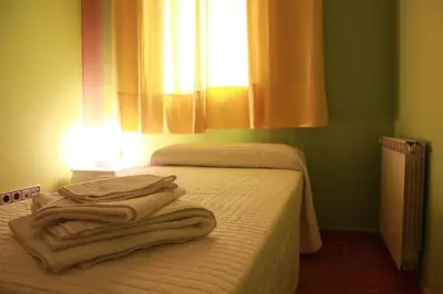 a bedroom with two beds and a window with towels at PISO EXTERIOR COMPLETO A 20 ' DE BARCELONA. in Sabadell
