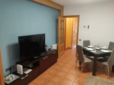 a living room with a dining table and a television at PISO EXTERIOR COMPLETO A 20 ' DE BARCELONA. in Sabadell