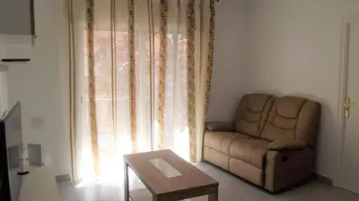 a living room with a couch and a table and a window at Apartamentos Atlas Terrassa III in Terrassa