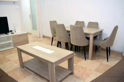 a dining room with a table and chairs and a tv at Apartamentos Atlas Terrassa II in Terrassa