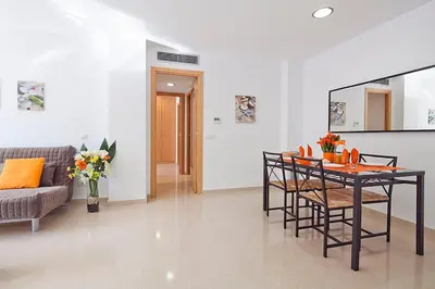 a living room with a table and chairs and a couch at Charmsuites Paralel in Barcelona