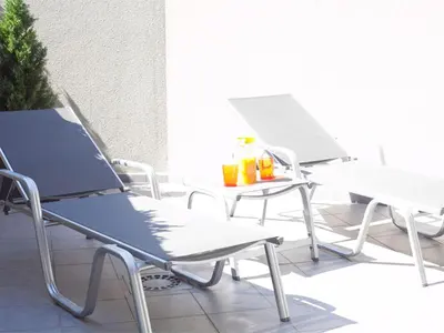 two chairs and a table with drinks on a balcony at Charmsuites Paralel in Barcelona