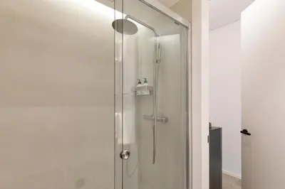 a shower with a glass door in a bathroom at Bcn Town Apartments Born in Barcelona