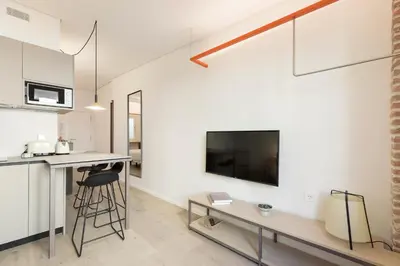 a living room with a table and a tv on a wall at Bcn Town Apartments Born in Barcelona