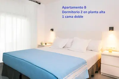 a bedroom with a blue bed with white pillows at Sitges Rustic Apartments in Sitges