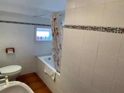 a bathroom with a toilet and a bath tub at Apartament Cal Negre in Vilassar de Mar