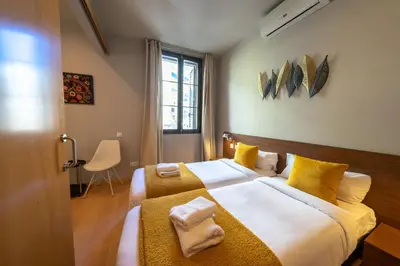 a bedroom with two beds with yellow pillows at Bonavista Apartments - Eixample in Barcelona