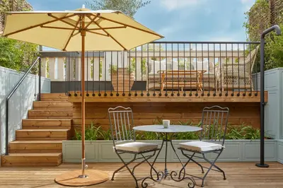 a table and two chairs and an umbrella on a deck at Miiro Borneta in Barcelona