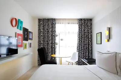 a bedroom with a bed and a table and a window at Vincci Bit in Barcelona