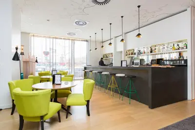a restaurant with a table and yellow chairs at Vincci Bit in Barcelona