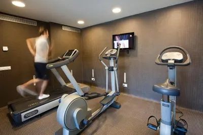 a room with two treadmill machines and a tv at Vincci Bit in Barcelona