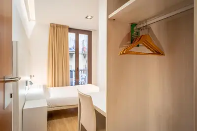 a room with a bed and a window at Hostal Fina in Barcelona