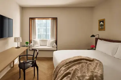 a bedroom with a bed and a desk and a chair at The Barcelona EDITION in Barcelona