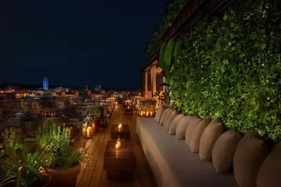 a balcony with benches and lights on a building at night at The Barcelona EDITION in Barcelona