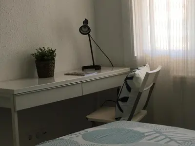 a desk with a lamp and a chair in a room at Solimar in Castelldefels