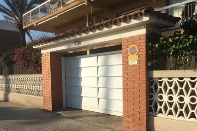 a white garage door on a brick building at Solimar in Castelldefels