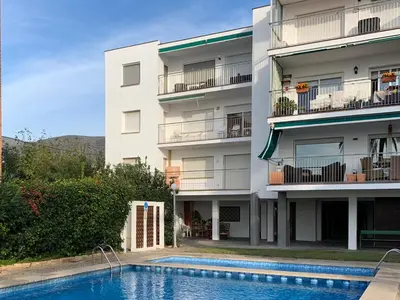 an apartment building with a swimming pool in front of it at Solimar in Castelldefels