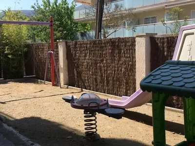 a playground with a seesaw and a swing at Solimar in Castelldefels