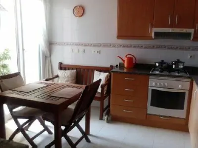 a kitchen with a table and a stove and a table and chairs at Playa y Sol in Cubelles