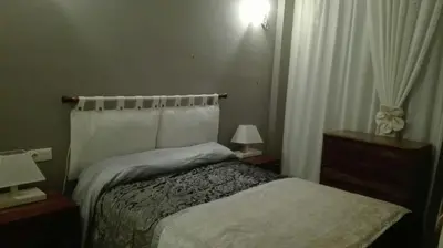 a bedroom with a bed and two night stands and two lamps at Playa y Sol in Cubelles