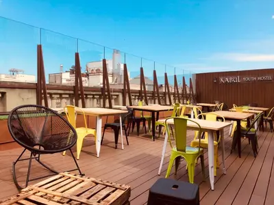 a patio with tables and chairs on a roof at Kabul Party Hostel Barcelona in Barcelona
