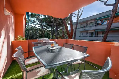 a table and chairs on a balcony with a building at Calm, Beach and Bikes in Castelldefels