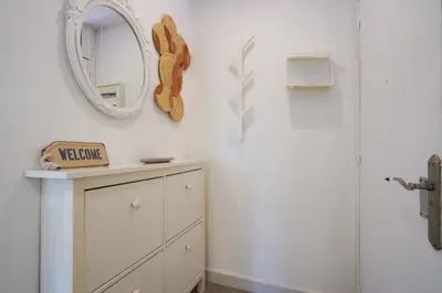 a white bathroom with a mirror and a dresser at Calm, Beach and Bikes in Castelldefels