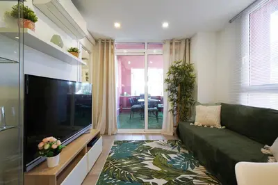 a living room with a couch and a flat screen tv at Calm, Beach and Bikes in Castelldefels