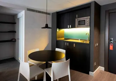 a dining room with a table and chairs and a kitchen at Hg City Suites Barcelona Apartments in Barcelona