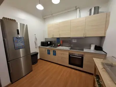 a kitchen with a stainless steel refrigerator and wooden cabinets at Mediterranean Hostel Barcelona in Barcelona