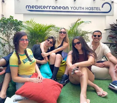 a group of people sitting in front of a hospital at Mediterranean Hostel Barcelona in Barcelona