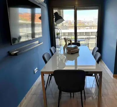 a dining room table with chairs and a blue wall at 8 min walk to the beach & 10 min walk to Convention Centre ! in Barcelona