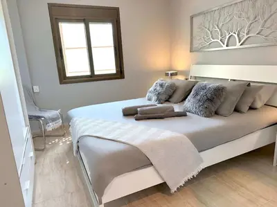 a large white bed in a room with a window at 8 min walk to the beach & 10 min walk to Convention Centre ! in Barcelona