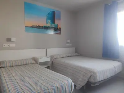 a room with two beds and a picture on the wall at Hotel Blauet by Bossh! Hotels in El Prat de Llobregat