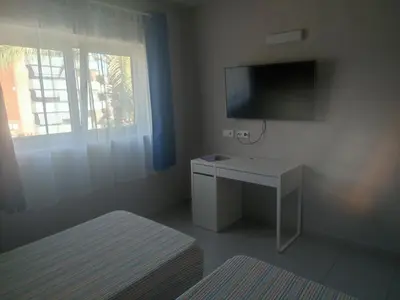 a room with a desk and a tv and a bed at Hotel Blauet by Bossh! Hotels in El Prat de Llobregat