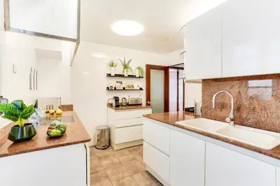 a kitchen with white cabinets and a sink at Sweett - Eixample Borrell in Barcelona