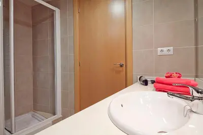 a bathroom with a white sink and a shower at Charmsuites Nou Rambla in Barcelona
