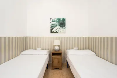 two beds in a room with a table between them at Apartament Clot 1 in Barcelona
