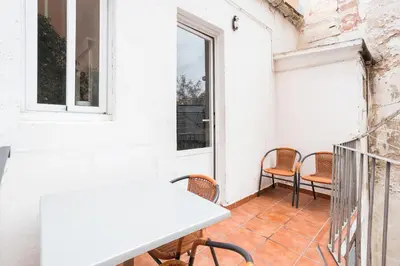 a balcony with chairs and a table and a window at Apartament Clot 1 in Barcelona