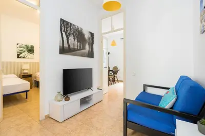 a living room with a blue couch and a tv at Apartament Clot 1 in Barcelona