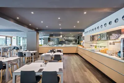 a restaurant with tables and chairs and a counter at Andante Hotel in Barcelona