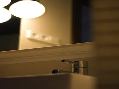 a bathroom sink with a mirror and a lamp at Hostal Badaloní in Badalona