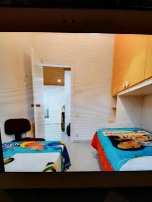 a room with two beds and a chair in it at Piso luminoso en Barcelona in Barcelona