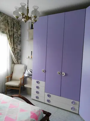 a purple cabinet in a bedroom with a chair at Piso luminoso en Barcelona in Barcelona