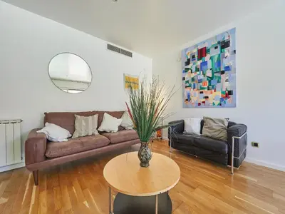 a living room with a couch and a table at BarcelonaForRent Vila Olimpica Pool Suites in Barcelona